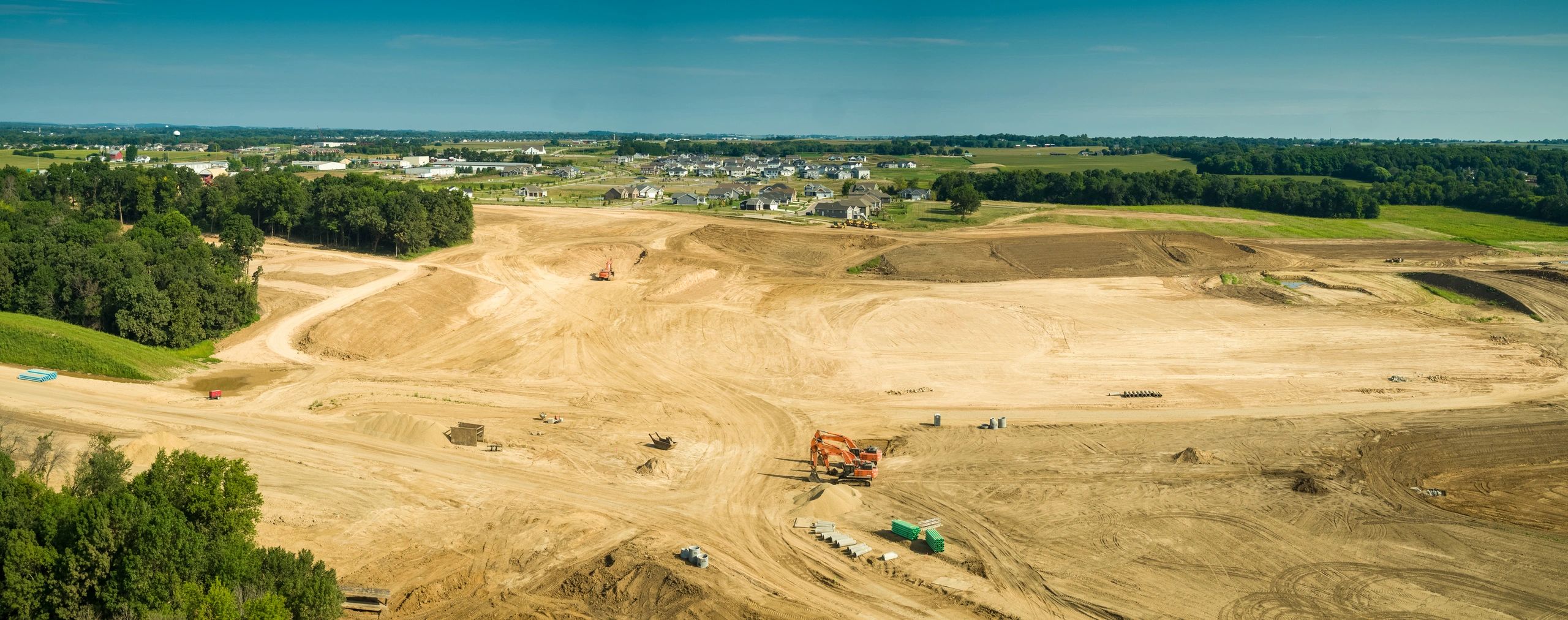 Panoramic aerial view of graded land and earthworks at a large site